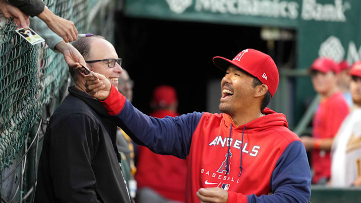 Oct 3, 2022; Oakland, California, USA; Los Angeles Angels catcher Kurt Suzuki (24) signs an autograph before the game against the Oakland Athletics at RingCentral Coliseum. Mandatory Credit: Darren Yamashita-Imagn Images