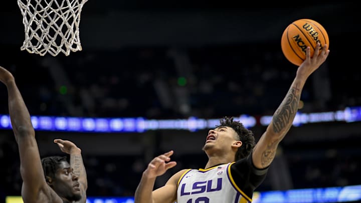 Mar 14, 2024; Nashville, TN, USA;  LSU Tigers forward Jalen Reed (13) lays the ball up over Mississippi State Bulldogs forward Cameron Matthews (4) during the second half at Bridgestone Arena. Mandatory Credit: Steve Roberts-Imagn Images