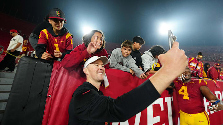 Nov 29, 2025; Los Angeles, California, USA; Southern California Trojans head coach Lincoln Riley poses with fans after the game against the UCLA Bruins at United Airlines Field at Los Angeles Memorial Coliseum. Mandatory Credit: Kirby Lee-Imagn Images