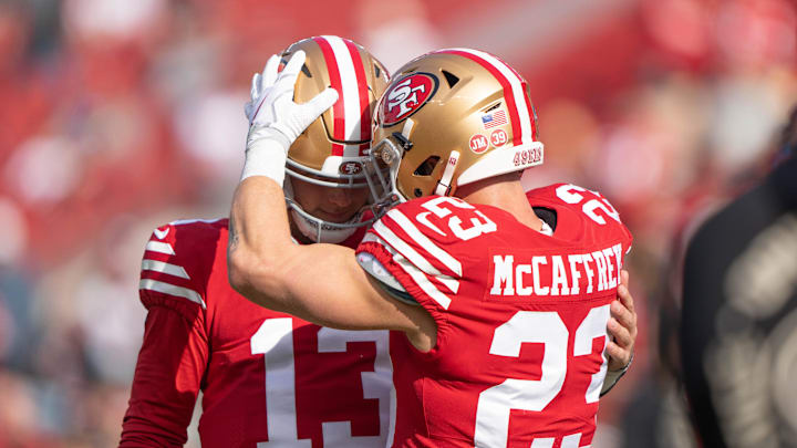 San Francisco 49ers running back Christian McCaffrey (23) embraces quarterback Brock Purdy (13).