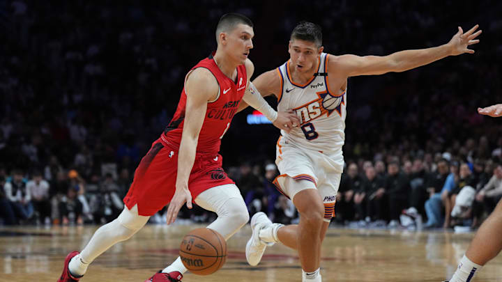 Dec 7, 2024; Miami, Florida, USA;  Miami Heat guard Tyler Herro (14) drives against Phoenix Suns guard Grayson Allen (8) during the second half at Kaseya Center. Mandatory Credit: Jim Rassol-Imagn Images