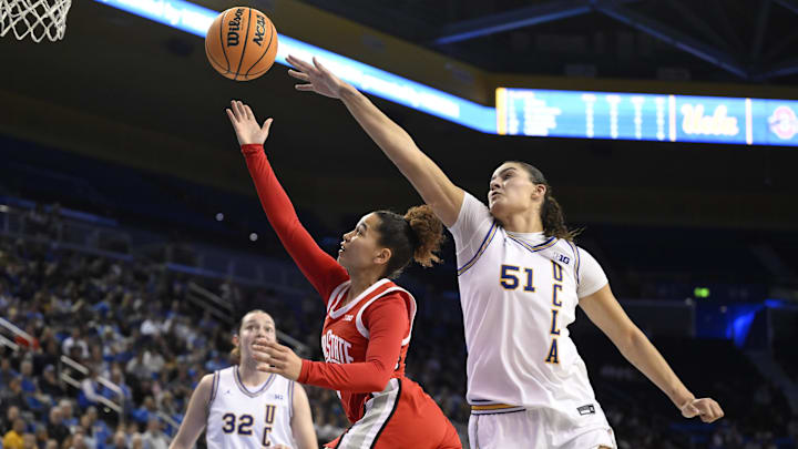 Feb 5, 2025; Los Angeles, California, USA; Ohio State Buckeyes guard Madison Greene (0) drives to the basket past UCLA Bruins center Lauren Betts (51) during the first quarter at Pauley Pavilion presented by Wescom. Mandatory Credit: Robert Hanashiro-Imagn Images