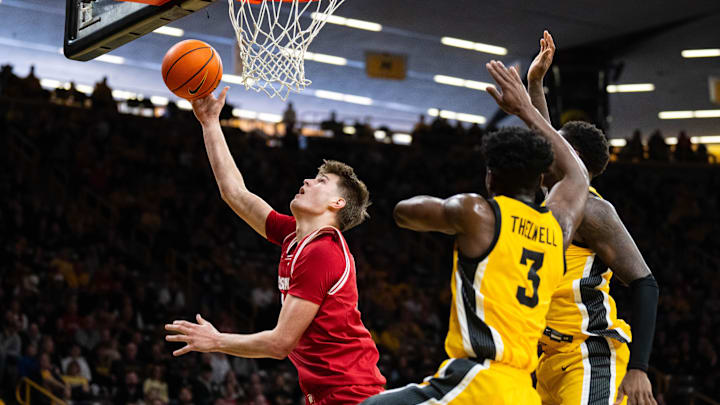 Feb 8, 2025; Iowa City, Iowa, USA; Wisconsin Badgers forward Nolan Winter (31) shoots the ball against Iowa Hawkeyes guard Drew Thelwell (3) and forward Seydou Traore (7) during the first half at Carver-Hawkeye Arena. 
