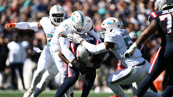 Oct 6, 2024; Foxborough, Massachusetts, USA; New England Patriots quarterback Jacoby Brissett (7) is sacked by linebacker Jordyn Brooks (20), linebacker Emmanuel Ogbah (91), and linebacker Tyus Bowser (51) during the first half at Gillette Stadium. 