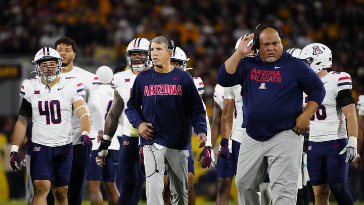 Arizona head coach Brent Brennan walks to the end zone with his team during a game against Arizona State at Mountain America Stadium in Tempe on Nov. 28, 2025.