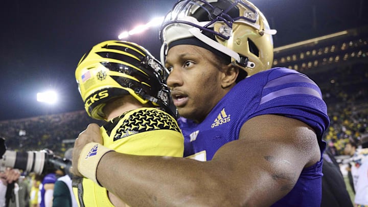 Huskies quarterback Michael Penix Jr. (9) embraces Oregon counterpart Bo Nix (10) after the 2022 game at Autzen Stadium. 