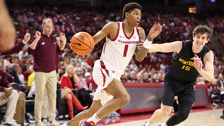 Nov 18, 2025; Fayetteville, Arkansas, USA; Arkansas Razorbacks guard Meleek Thomas (1) drives against Winthrop Eagles forward Tommy Kamarad (15) during the first half at Bud Walton Arena. Mandatory Credit: Nelson Chenault-Imagn Images