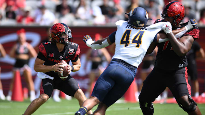 Sep 24, 2022; San Diego, California, USA; San Diego State Aztecs quarterback Braxton Burmeister (5) is pressured by Toledo Rockets linebacker D'Andre Ragin (44) during the first half at Snapdragon Stadium. Mandatory Credit: Orlando Ramirez-Imagn Images