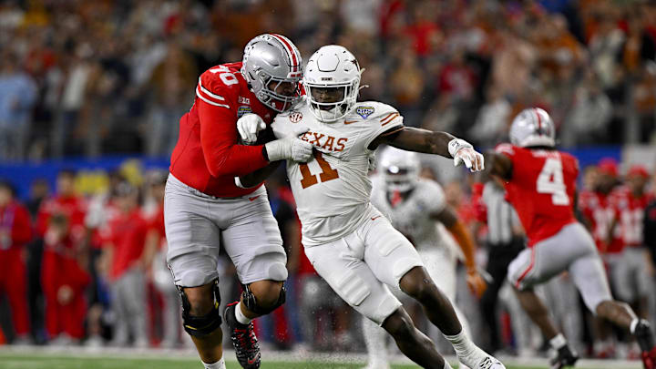 Jan 10, 2025; Arlington, TX, USA; Ohio State Buckeyes offensive lineman Tegra Tshabola (77) blocks Texas Longhorns linebacker Colin Simmons (11) during the game between the Texas Longhorns and the Ohio State Buckeyes at AT&T Stadium. Mandatory Credit: Jerome Miron-Imagn Images Jan 10, 2025; Arlington, TX, USA; Ohio State Buckeyes offensive lineman Tegra Tshabola (77) blocks Texas Longhorns linebacker Colin Simmons (11) during the game between the Texas Longhorns and the Ohio State Buckeyes at AT&T Stadium. Mandatory Credit: Jerome Miron-Imagn Images