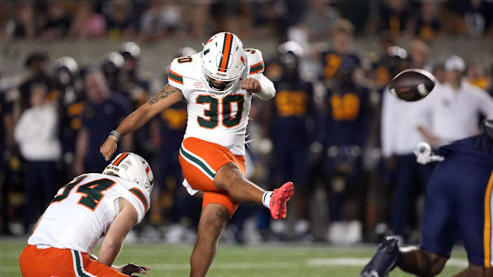 Oct 5, 2024; Berkeley, California, USA; Miami Hurricanes place kicker Andres Borregales (30) kicks an extra point against the California Golden Bears during the fourth quarter at California Memorial Stadium. Mandatory Credit: Darren Yamashita-Imagn Images