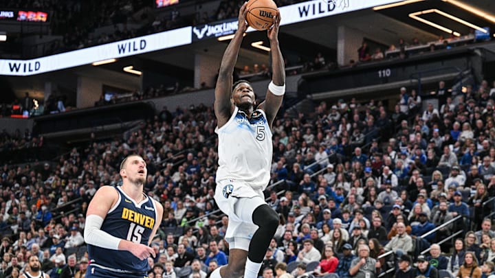 Jan 25, 2025; Minneapolis, Minnesota, USA; Minnesota Timberwolves guard Anthony Edwards (5) goes to the basket for a slam dunk over Denver Nuggets center Nikola Jokic (15) during the third quarter at Target Center. Mandatory Credit: Jeffrey Becker-Imagn Images