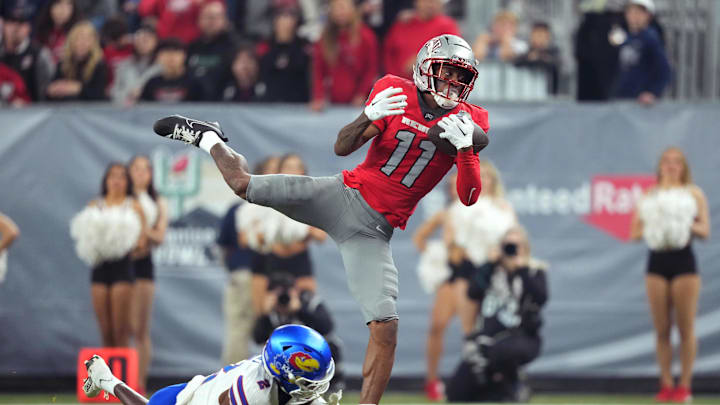 Dec 26, 2023; Phoenix, AZ, USA; UNLV Rebels wide receiver Ricky White (11) catches a touchdown pass against Kansas Jayhawks cornerback Cobee Bryant (2) during the second half at Chase Field. Mandatory Credit: Joe Camporeale-USA TODAY Sports