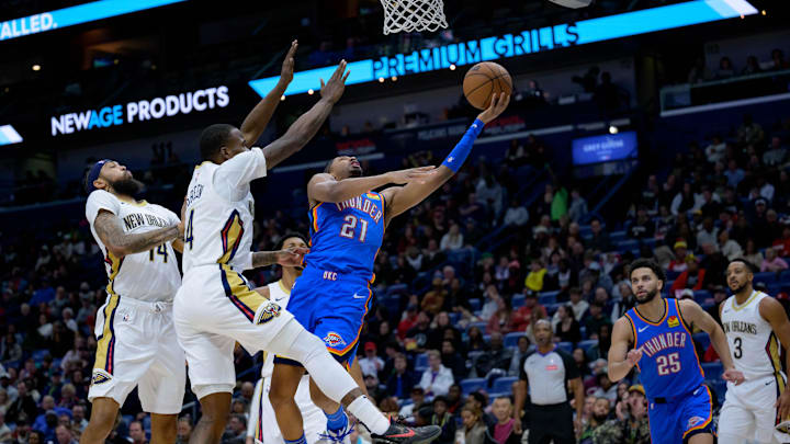 Dec 7, 2024; New Orleans, Louisiana, USA; Oklahoma City Thunder guard Aaron Wiggins (21) shoots against New Orleans Pelicans guard Javonte Green (4) and New Orleans Pelicans forward Brandon Ingram (14) during the first half at Smoothie King Center. Mandatory Credit: Matthew Hinton-Imagn Images