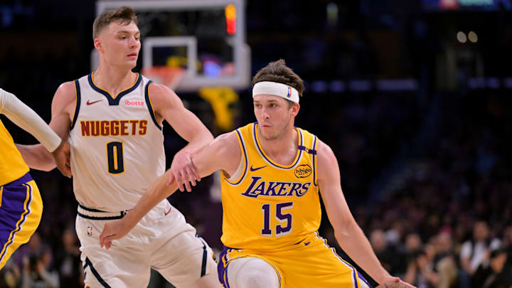 Mar 19, 2025; Los Angeles, California, USA; Los Angeles Lakers guard Austin Reaves (15) drives past Denver Nuggets guard Christian Braun (0) in the first half at Crypto.com Arena. Mandatory Credit: Jayne Kamin-Oncea-Imagn Images