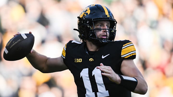 Nov 22, 2025; Iowa City, Iowa, USA; Iowa Hawkeyes quarterback Mark Gronowski (11) rolls out to throws a pass against the Michigan State Spartans during the first quarter at Kinnick Stadium. Mandatory Credit: Jeffrey Becker-Imagn Images