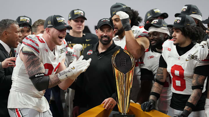 Jan 20, 2025; Atlanta, GA, USA; Ohio State Buckeyes defensive end Jack Sawyer (33) and Ohio State Buckeyes head coach Ryan Day celebrate on the podium after defeating the Notre Dame Fighting Irish in the CFP National Championship college football game at Mercedes-Benz Stadium. Mandatory Credit: Kirby Lee-Imagn Images