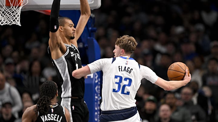 Feb 5, 2026; Dallas, Texas, USA; Dallas Mavericks forward Cooper Flagg (32) passes the ball by San Antonio Spurs forward Victor Wembanyama (1) during the second half at the American Airlines Center. Mandatory Credit: Jerome Miron-Imagn Images