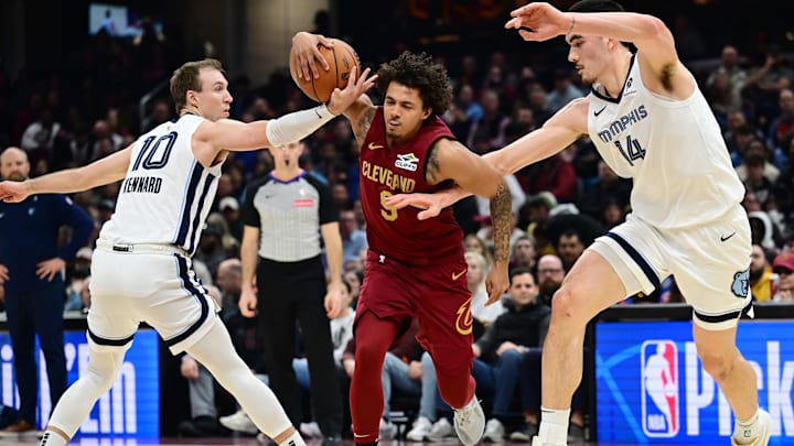 Feb 23, 2025; Cleveland, Ohio, USA; Cleveland Cavaliers guard Craig Porter Jr. (9) drives to the basket between Memphis Grizzlies guard Luke Kennard (10) and center Zach Edey (14) during the first half at Rocket Arena. Mandatory Credit: Ken Blaze-Imagn Images