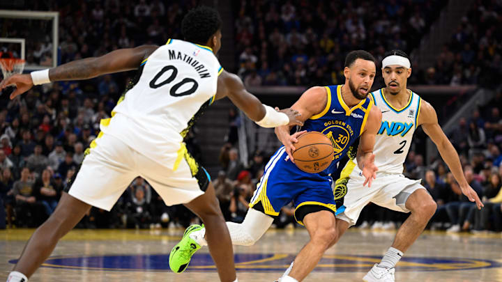 Dec 23, 2024; San Francisco, California, USA; Golden State Warriors guard Stephen Curry (30) drives to the basket against Indiana Pacers guard Bennedict Mathurin (00) and guard Andrew Nembhard (2) in the fourth quarter at Chase Center. Mandatory Credit: Eakin Howard-Imagn Images