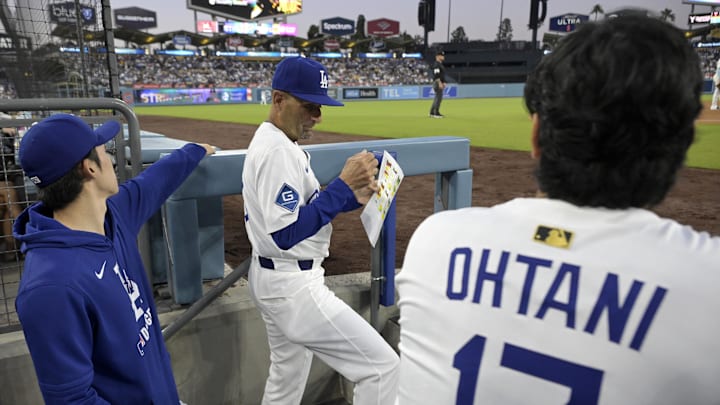 Los Angeles Dodgers designated hitter Shohei Ohtani (17) along with starting pitcher Roki Sasaki (11) listen to third base coach Dino Ebel (91) in the dugout during the game against the Minnesota Twins at Dodger Stadium on July 22.