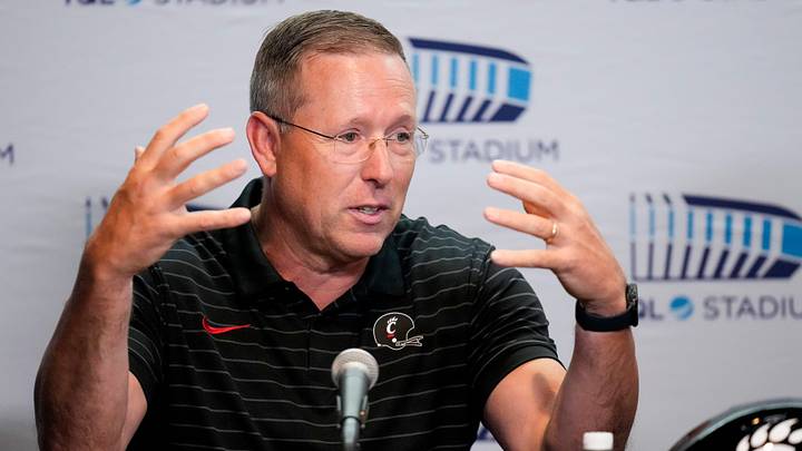University of Cincinnati football head coach Scott Satterfield takes questions during a press conference to announce the neutral site for the upcoming Battle of the Victory Bell football game at TQL Stadium in Cincinnati on Tuesday, June 16, 2026. The rivalry college football game between the University of Cincinnati Bearcats and the Miami RedHawks will be played at TQL Stadium. University of Cincinnati football head coach Scott Satterfield takes questions during a press conference to announce the neutral site for the upcoming Battle of the Victory Bell football game at TQL Stadium in Cincinnati on Tuesday, June 16, 2026. The rivalry college football game between the University of Cincinnati Bearcats and the Miami RedHawks will be played at TQL Stadium.