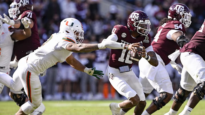 Dec 20, 2025; College Station, TX, USA; Texas A&M Aggies quarterback Marcel Reed (10) eludes the tackle of Miami Hurricanes defensive lineman Akheem Mesidor (3) during the game between the Aggies and the Hurricanes at Kyle Field. Mandatory Credit: Jerome Miron-Imagn Images