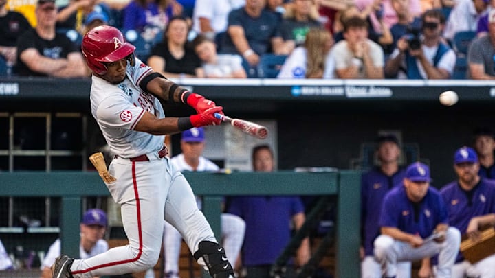 Jun 18, 2025; Omaha, Neb, USA; Arkansas Razorbacks center fielder Justin Thomas Jr. (4) hits a single against the LSU Tigers during the eighth inning at Charles Schwab Field. Mandatory Credit: Dylan Widger-Imagn Images