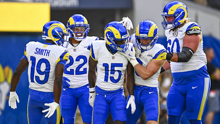Aug 16, 2025; Inglewood, California, USA; Los Angeles Rams wide receiver Konata Mumpfield (15) celebrates a touchdown with linebacker Byron Young (0), running back Blake Corum (22), and wide receiver Xavier Smith (19) against the Los Angeles Chargers during the first quarter at SoFi Stadium. Mandatory Credit: Jonathan Hui-Imagn Images