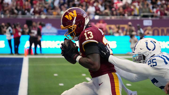 Oct 4, 2026; Tottenham, ENG;  Washington Commanders wide receiver Treylon Burks (13) scores a touchdown against Indianapolis Colts safety AJ Haulcy (25) during the third quarter at Tottenham Hotspur Stadium.  Mandatory Credit: Kirby Lee-Imagn Images
