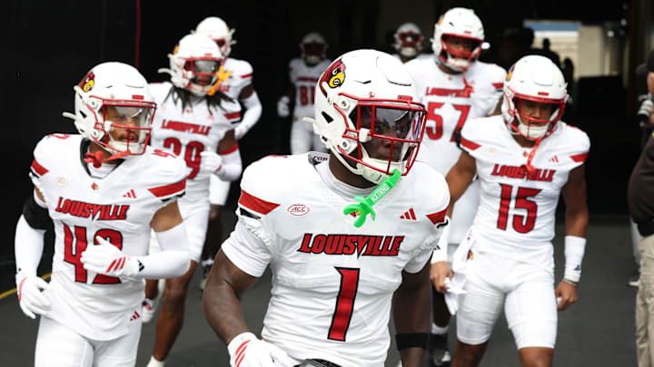 Sep 27, 2025; Pittsburgh, Pennsylvania, USA;  Louisville Cardinals running back Isaac Brown (1) leads teammates onto the field against the Pittsburgh Panthers at Acrisure Stadium. Mandatory Credit: Charles LeClaire-Imagn Images