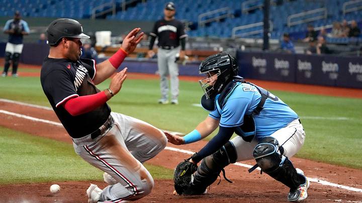 A Minnesota Twins infielder slides into home safely. A Minnesota Twins infielder slides into home safely.