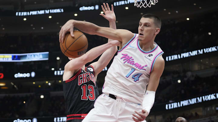 Apr 9, 2025; Chicago, Illinois, USA; Miami Heat guard Tyler Herro (14) and Chicago Bulls guard Kevin Huerter (13) go for the ball during the first quarter at United Center. Mandatory Credit: David Banks-Imagn Images