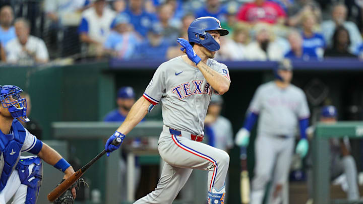 Aug 18, 2025; Kansas City, Missouri, USA; Texas Rangers center fielder Evan Carter (32) hits a single during the fourth inning against the Kansas City Royals at Kauffman Stadium. Mandatory Credit: Jay Biggerstaff-Imagn Images