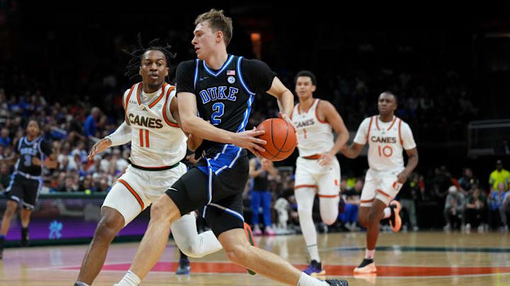Feb 25, 2025; Coral Gables, Florida, USA;  Duke Blue Devils guard Cooper Flagg (2) drives to the basket as Miami (Fl) Hurricanes guard A.J. Staton-McCray (11) defends during the first half at Watsco Center. Mandatory Credit: Jim Rassol-Imagn Images