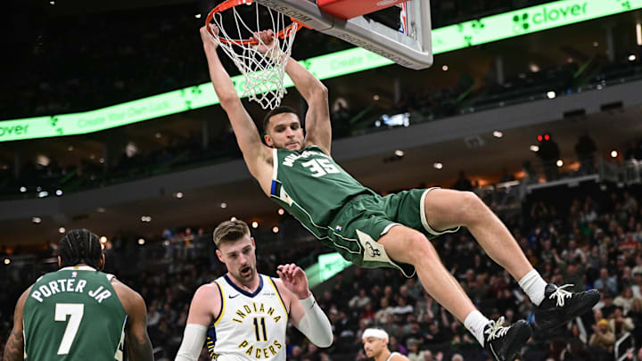 Feb 6, 2026; Milwaukee, Wisconsin, USA;  Milwaukee Bucks forward Pete Nance (35) hangs on the basket after dunking a shot against Indiana Pacers forward Micah Potter (11) in the fourth quarter at Fiserv Forum. Mandatory Credit: Benny Sieu-Imagn Images