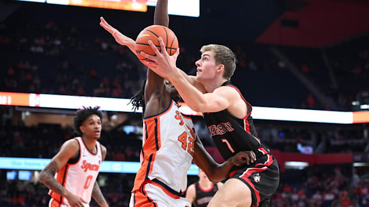 Dec 20, 2025; Syracuse, New York, USA; Northeastern Huskies forward Youri Fritz (7) takes a shot near the basket as Syracuse Orange forward William Kyle III (42) defends in the first half at the JMA Wireless Dome. Mandatory Credit: Mark Konezny-Imagn Images