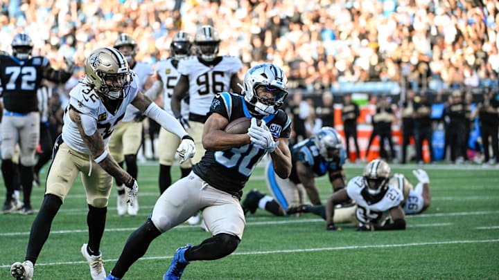 Nov 3, 2024; Charlotte, North Carolina, USA; Carolina Panthers running back Chuba Hubbard (30) scores a touchdown as New Orleans Saints safety Tyrann Mathieu (32) defends in the fourth qarter at Bank of America Stadium. Mandatory Credit: Bob Donnan-Imagn Images