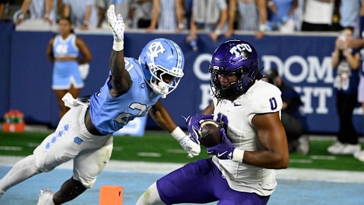 Sep 1, 2025; Chapel Hill, North Carolina, USA; TCU Horned Frogs tight end DJ Rogers (0) catches a touchdown pass as North Carolina Tar Heels defensive back Kaleb Cost (21) defends in the fourth quarter at Kenan Stadium. 