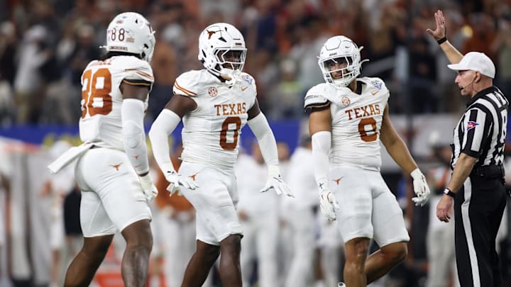 Jan 10, 2025; Arlington, Texas, USA; Texas Longhorns linebacker Anthony Hill Jr. (0) celebrates with linebacker Barryn Sorrell (88) and linebacker Trey Moore (8) after a play during the second quarter of the College Football Playoff semifinal against the Ohio State Buckeyes in the Cotton Bowl at AT&T Stadium. Mandatory Credit: Tim Heitman-Imagn Images Jan 10, 2025; Arlington, Texas, USA; Texas Longhorns linebacker Anthony Hill Jr. (0) celebrates with linebacker Barryn Sorrell (88) and linebacker Trey Moore (8) after a play during the second quarter of the College Football Playoff semifinal against the Ohio State Buckeyes in the Cotton Bowl at AT&T Stadium. Mandatory Credit: Tim Heitman-Imagn Images