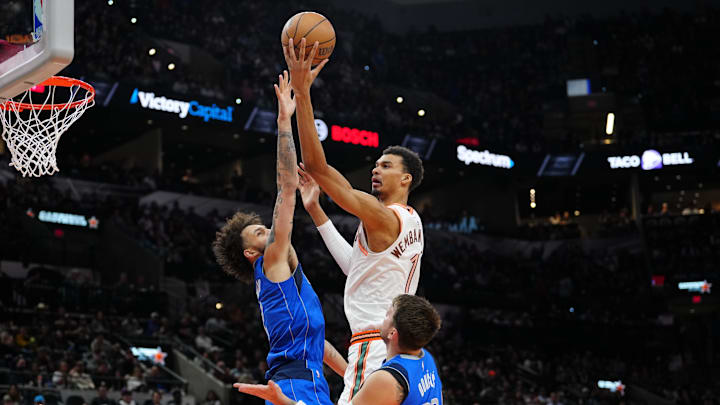 Mar 19, 2024; San Antonio, Texas, USA;  San Antonio Spurs center Victor Wembanyama (1) shoots over Dallas Mavericks center Dereck Lively II (2) and guard Luka Doncic (77) in the first half at Frost Bank Center. Mandatory Credit: Daniel Dunn-Imagn Images