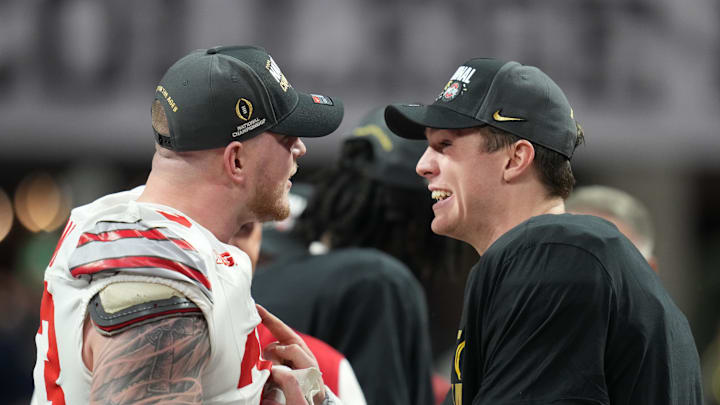 Jan 20, 2025; Atlanta, GA, USA; Ohio State Buckeyes defensive end Jack Sawyer (33) and Ohio State Buckeyes quarterback Will Howard (18) celebrate on the podium after defeating the Notre Dame Fighting Irish in the CFP National Championship college football game at Mercedes-Benz Stadium. Mandatory Credit: Kirby Lee-Imagn Images