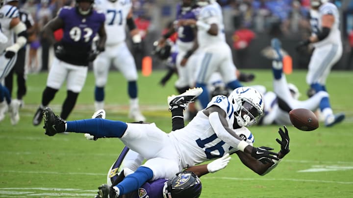 Indianapolis Colts wide receiver Ashton Dulin (16) bobbles the ball while being tackled by Baltimore Ravens cornerback Jalyn Armour-Davis (5).Mandatory Credit: Rafael Suanes-Imagn Images