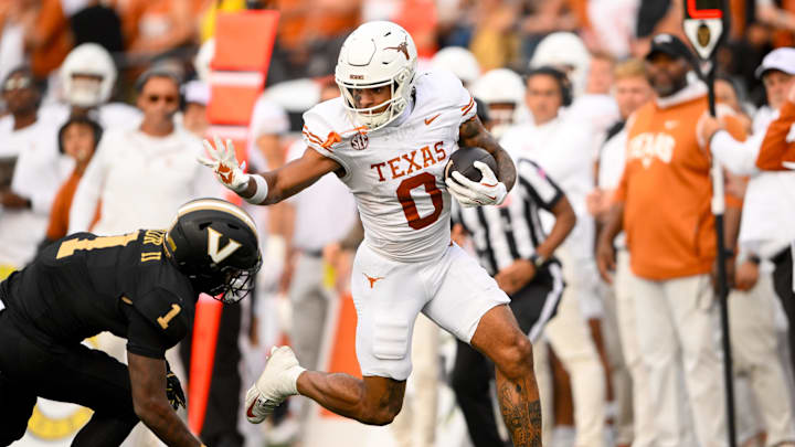 Oct 26, 2024; Nashville, Tennessee, USA; Texas Longhorns wide receiver DeAndre Moore Jr. (0) stiff arms Vanderbilt Commodores safety CJ Taylor (1) as he crosses the goal line  during the first half at FirstBank Stadium. Mandatory Credit: Steve Roberts-Imagn Images