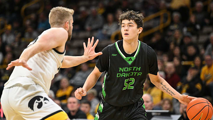 Nov 7, 2023; Iowa City, Iowa, USA; North Dakota Fighting Hawks guard Treysen Eaglestaff (52) dribbles against Iowa Hawkeyes forward Ben Krikke (23) during the first half at Carver-Hawkeye Arena. Mandatory Credit: Jeffrey Becker-Imagn Images