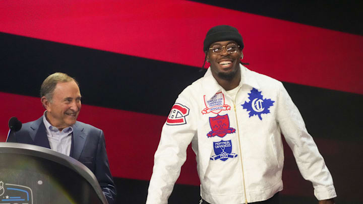 Jun 27, 2025; Los Angeles, California, USA; Oklahoma City Thunder guard Luguentz Dort presses the trade button for the Montreal Canadiens on the 16th overall pick as NHL Commissioner Gary Bettman watches in the first round of the 2025 NHL Draft at Peacock Theater. Mandatory Credit: Kirby Lee-Imagn Images