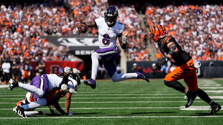 Baltimore Ravens quarterback Lamar Jackson (8) leaps away from Cincinnati Bengals defensive end Sam Hubbard (94) on a keeper in the first quarter of the NFL Week 5 game between the Cincinnati Bengals and Baltimore Ravens at Paycor Stadium in downtown Cincinnati on Sunday, Oct. 6, 2024. The Bengals led 17-14 at halftime.