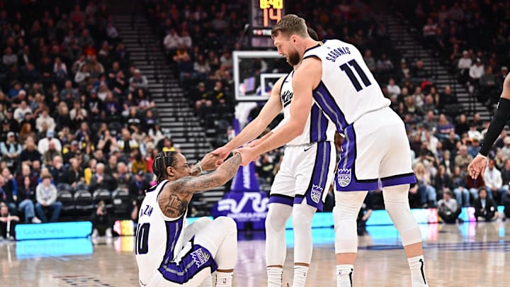 Feb 26, 2025; Salt Lake City, Utah, USA;  Sacramento Kings guard DeMar DeRozan (10) is helped up by teammates guard Zach LaVine (8) and forward Domantas Sabonis (11) in the first half against the Utah Jazz at Delta Center. Mandatory Credit: Jamie Sabau-Imagn Images