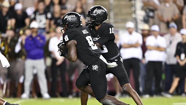 Oct 26, 2024; College Station, Texas, USA; Texas A&M Aggies quarterback Marcel Reed (10) hands off the ball to running back Le'Veon Moss (8) during the fourth quarter against the LSU Tigers. The Aggies defeated the Tigers 38-23; at Kyle Field. Mandatory Credit: Maria Lysaker-Imagn Images.  
