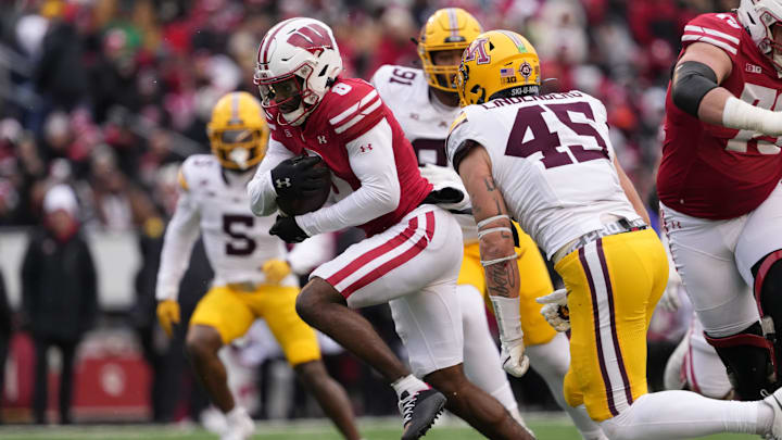 Nov 29, 2024; Madison, Wisconsin, USA;  Wisconsin Badgers wide receiver Vinny Anthony II (8) rushes with the football in front of Minnesota Golden Gophers linebacker Cody Lindenberg (45) after catching a pass during the third quarter at Camp Randall Stadium.