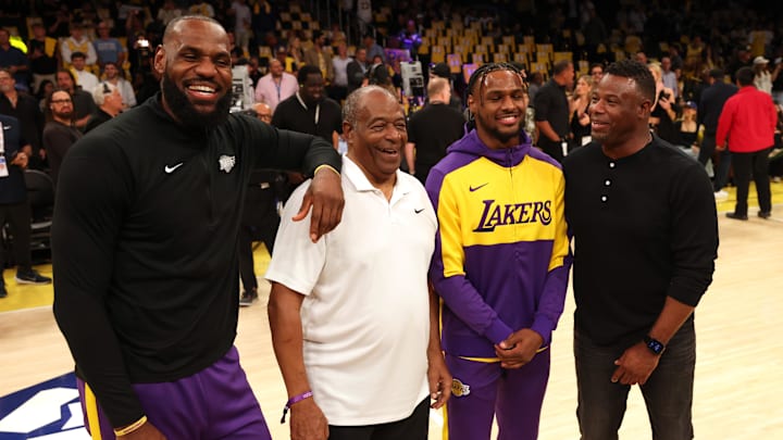 Los Angeles Lakers forward LeBron James (23) and his son, guard Bronny James (9) talk to former Major League Baseball players Ken Griffey, Sr. and Ken Griffey, Jr. before a game against the Minnesota Timberwolves at Crypto.com Arena on Oct 22.